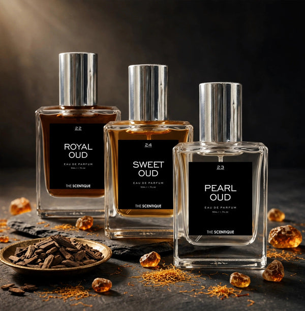 Oud Trio — three oud bottles on slate with oud chips, amber resin, saffron